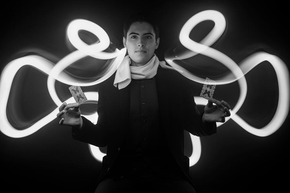 Black and white light-painting portrait of Rado Sheytanoff holding playing cards