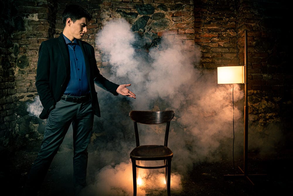 Rado Sheytanoff presenting an empty chair surrounded by smoke